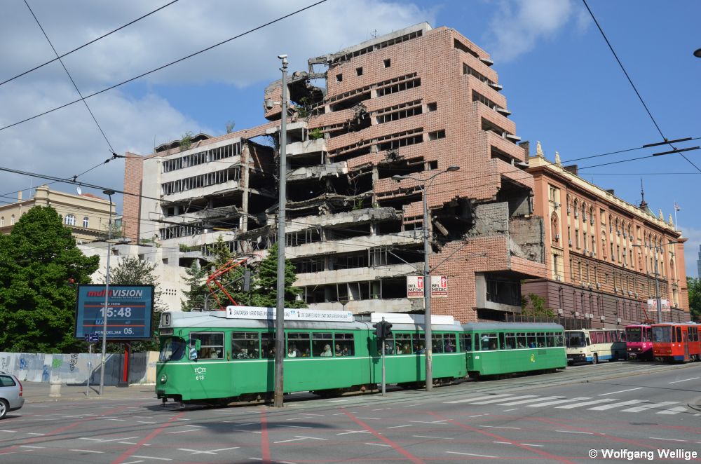 Der ex-Basler Wagen 613 passiert am 5. Mai 2014 als Linie 9 hinter der Haltestelle Trg Slavija / Трг Славија (Slavia-Platz) das bei NATO-Bombenangriffen im Kosovokrieg 1999 zerstörte Verteidigungsministerium. Auf dem Beiwagen 1438 ist sogar noch das Logo der Basler Verkehrsbetriebe zu erkennen.