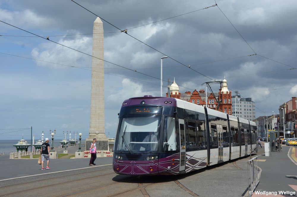 Vor dem Obelisken ('Blackpool Cenotaph') hat der Flexity Outlook 2 Nummer 007 am 05.07.2015 gerade die Haltestelle North Pier verlassen, die Gleisstümpfe am unteren Bildrand sind eine Bauvorleistung für die Stichstrecke zum Bahnhof.