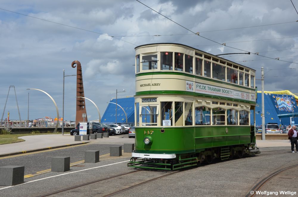 In der Wendeschleife Pleasure Beach wartet die historische Doppeldecker-Tram 147 aus dem Jahre 1924 am 05.07.2015 die Abfahrtszeit für die nächste Runde zum North Pier ab, die gelbe Röhre hinter dem Wagen ist die Rutsche eines Spaßbades.